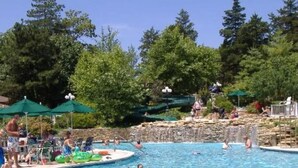 A swimming pool surrounded by trees and umbrellas. - Margaritaville Resort~ Close to the Pool~ Large Home-Amazing Water Views-Recently Redecorated (Osage Beach)