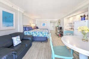A compact hotel room with a bed, a sofa, a dining table, and a kitchenette. - Oceanfront Condo w/Balcony |Sleeps 4 |Sunrise View (Daytona Beach)