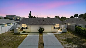 A single-story house with a garage, a driveway, and a small front yard. - Cozy Beach House ( Walking Distance to Beach) (New Smyrna Beach)