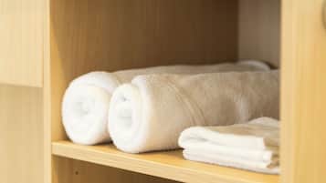 Un estante de madera con toallas blancas dobladas con cuidado.