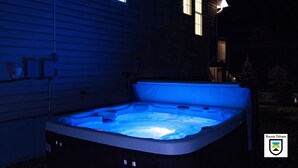 A hot tub in a backyard with a house in the background.