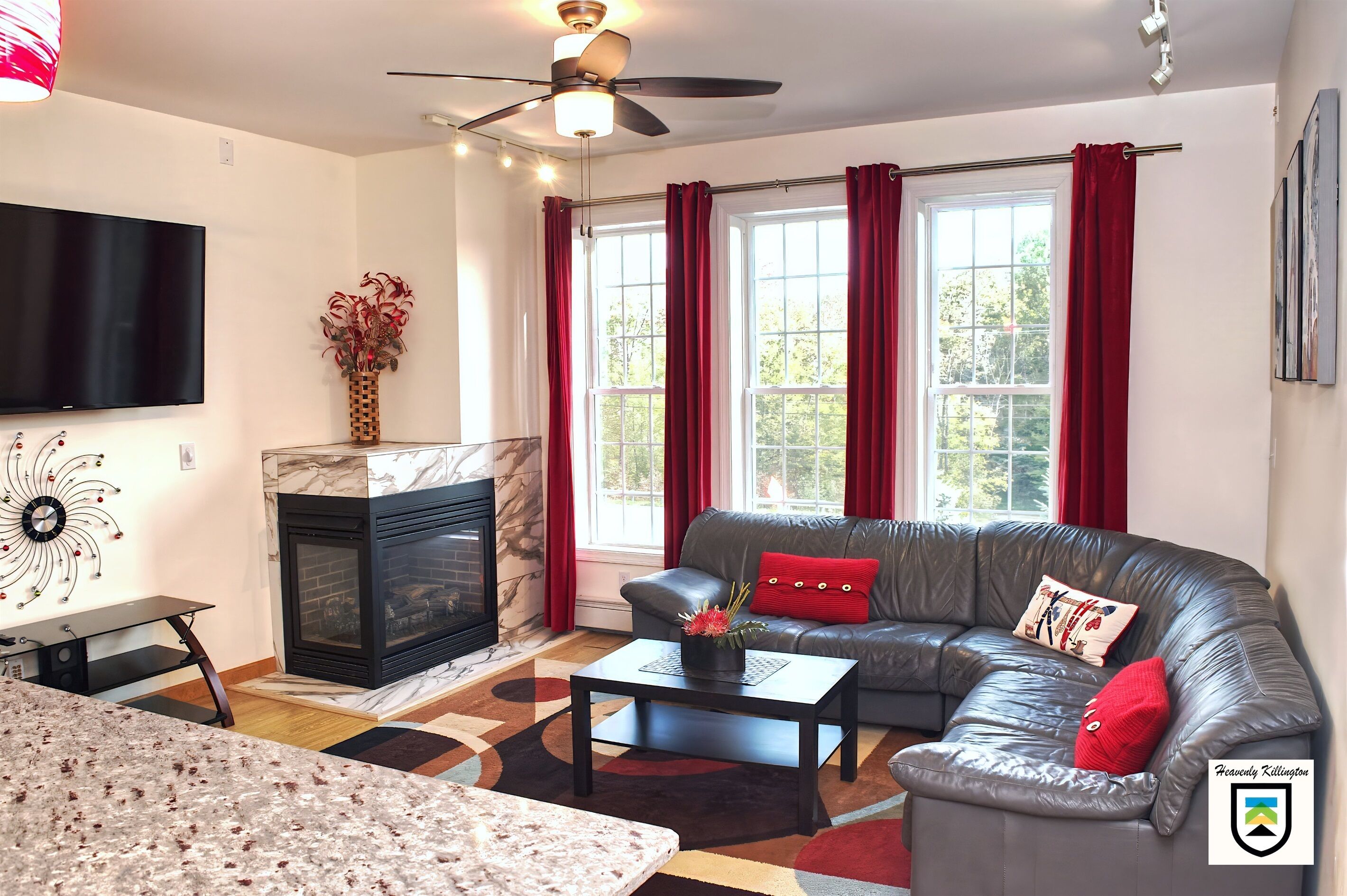 A living room with a fireplace, a sofa, a coffee table, and a TV.