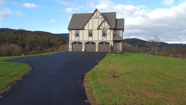 A large two-story house with a garage, surrounded by a grassy field and hills in the background. - Weekend getaway short distance from DC/Northern Virginia (Markham)