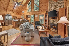 Ein gemütliches Blockhaus-Interieur mit Küche, Essbereich, Wohnzimmer und Kamin.