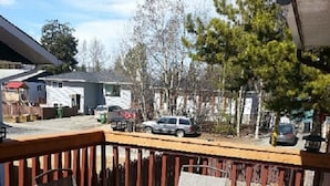 A wooden deck with a metal table and two chairs. - Wild North Bed & Rest (Whitehorse)