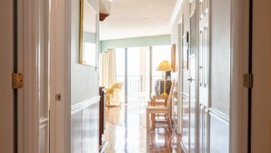A hallway with polished wooden floors, white walls, and a view into a room with a chair and lamp. - Surfmaster - Oceanfront 3 Bedroom/3 Bath  Beautiful!!! Great Rates!! (Garden City)