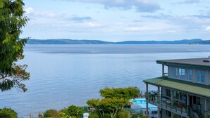 A waterfront property with a pool, a covered patio, and a view of the water. - Oceanfront 2 bedroom Condo w/Stunning Views~Heated Pool/Hot Tub/Dock (Nanaimo)