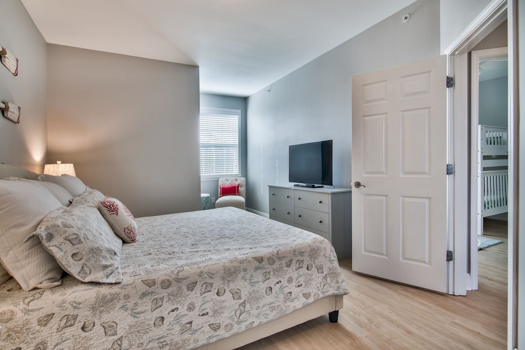Ein Schlafzimmer mit Bett, Fernseher, Kommode und Schrank.