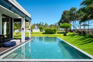 Una piscina al aire libre, sillones reclinables de piscina