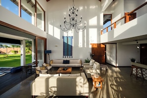 A spacious living area with a chandelier, sofas, and a coffee table.