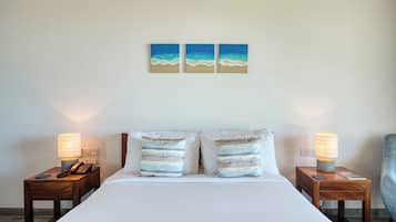 A hotel room with a bed, two bedside tables, lamps, and two wall-mounted paintings.