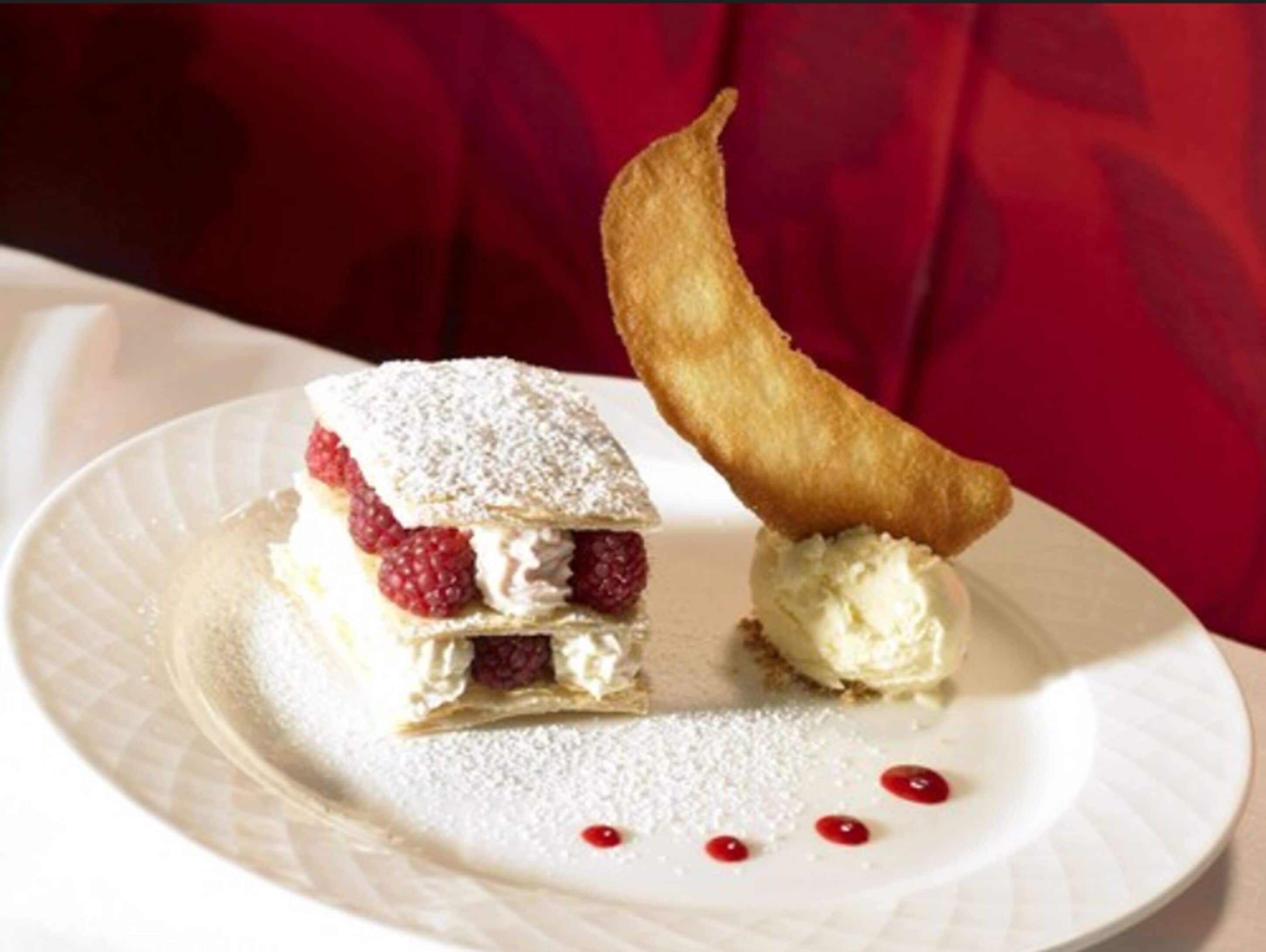 A dessert with a pastry and ice cream on a plate.