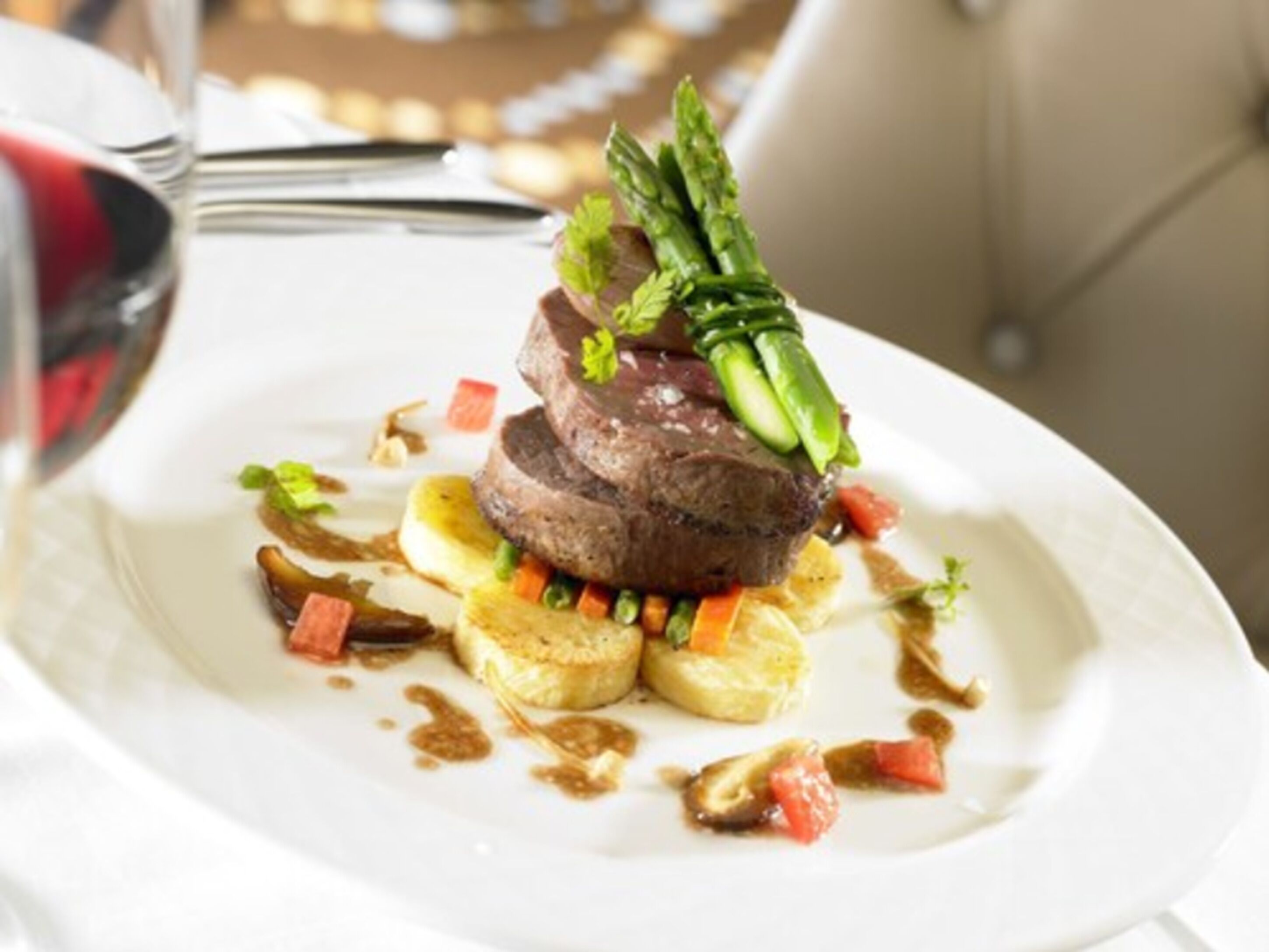 A plated dish with steak, asparagus, and vegetables.