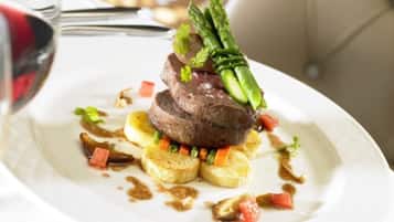 A plated dish with steak, asparagus, and vegetables.