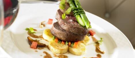 A plated dish with steak, asparagus, and vegetables.