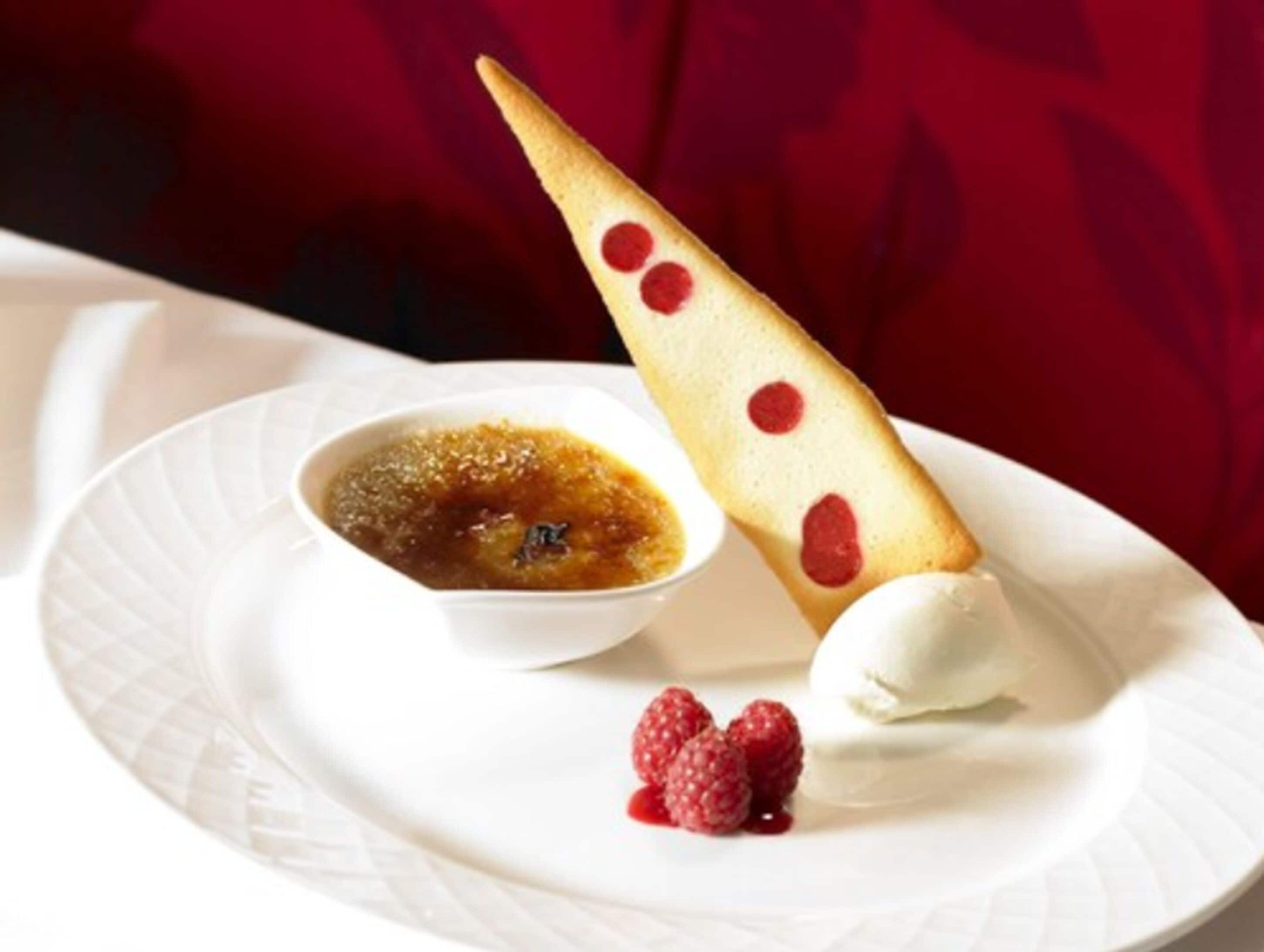 A dessert plate with a pastry, a small bowl of sauce, and a scoop of ice cream.