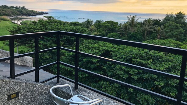 A balcony with a view of the ocean and a grassy area. - Tranquil Sea Hotel (Hengchun)