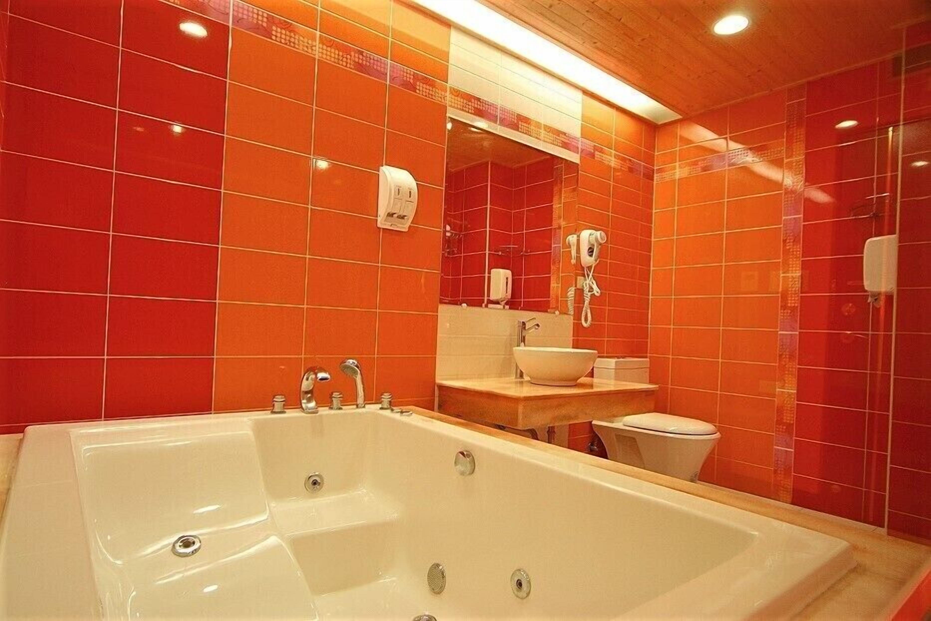 Un baño con una bañera grande, un lavamanos y un inodoro.