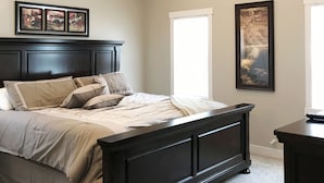 A bedroom with a large bed, a ceiling fan, and two windows. - Luxury Gun Lake 4 Bed 2 Bath Home W/paddleboards/kayaks, Free Wi-fi (Wayland)