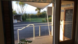 A view through a door with a 'Welcome to View' sign, a chalkboard with a list of activities, and a potted plant on the floor. - Stay in School by the Sea (Dunedin Area)