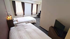 Una habitación de hotel con dos camas, un escritorio, una silla, un televisor y cortinas.