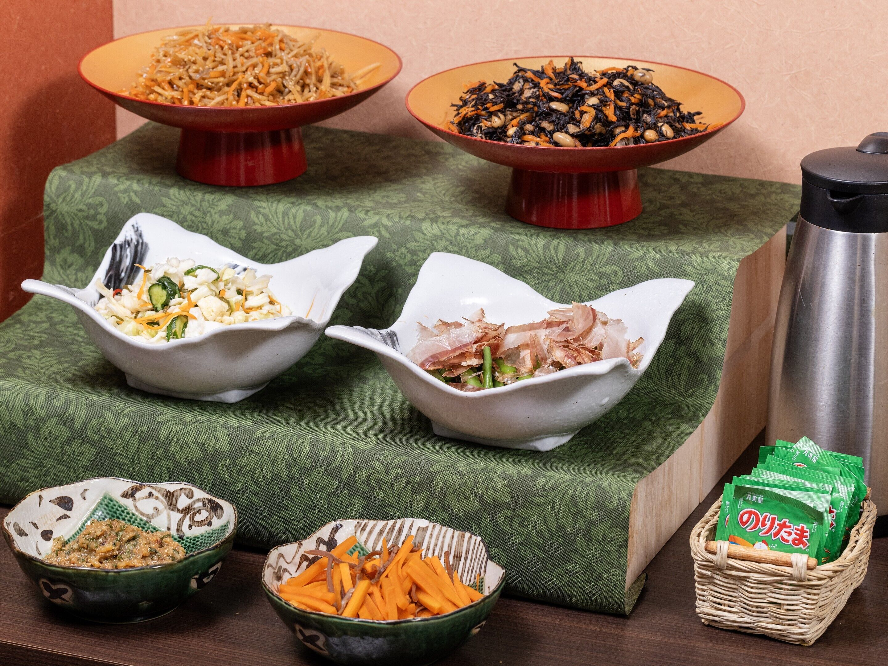 A dining table with various dishes and a thermos.
