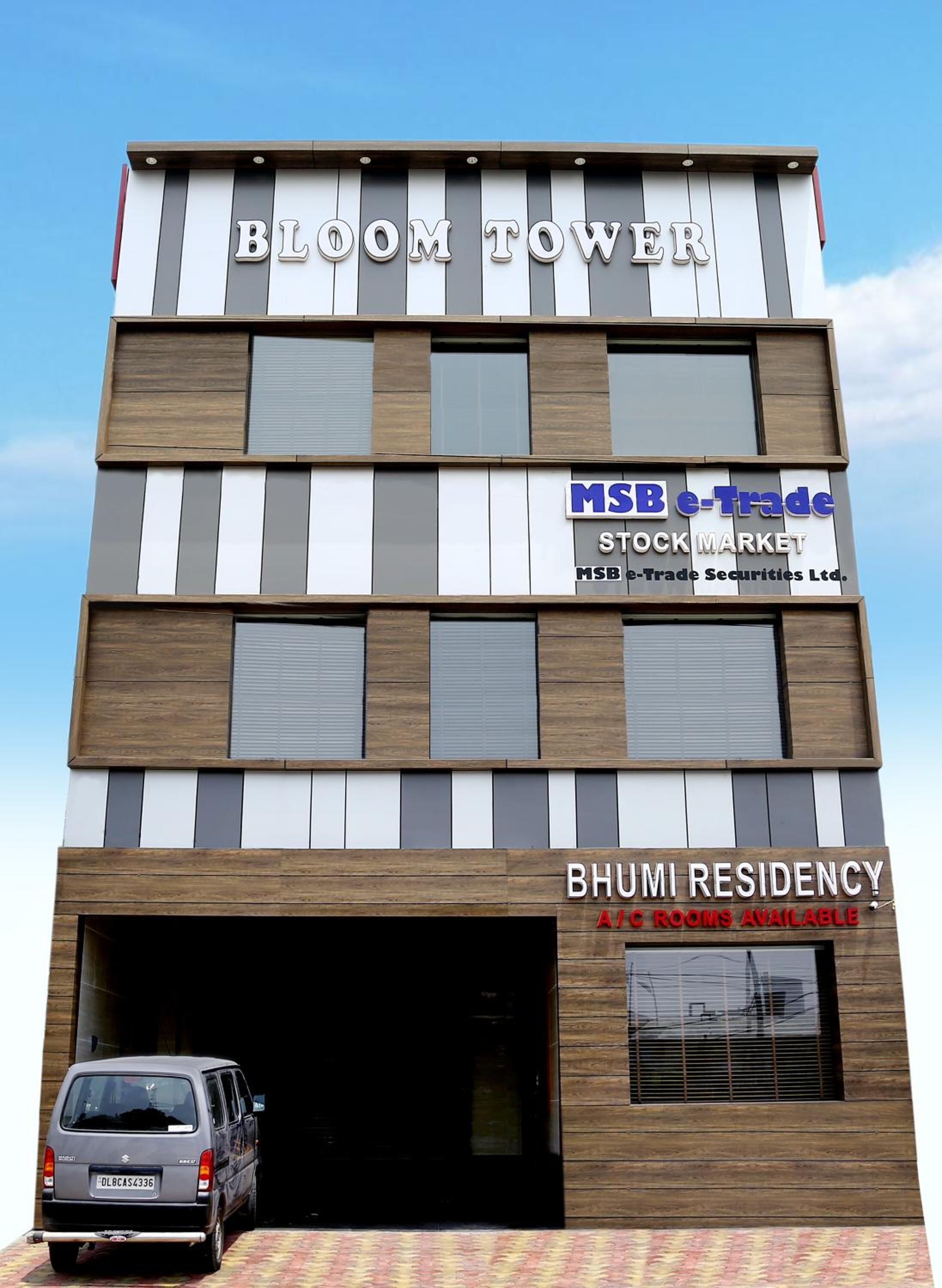 Un immeuble à plusieurs étages, avec une enseigne indiquant « MSB e-Trade, MARCHÉ BOURSIER » et « BHUMI RESIDENCY », proposant des chambres climatisées.