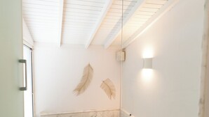 Un baño moderno con una bañera grande, una encimera de mármol y un box de ducha de vidrio.