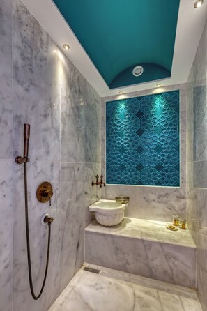 Une salle de bain équipée d’une douche, d’un lavabo et d’un panneau mural décoratif.