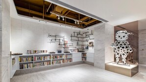 Une bibliothèque moderne avec des sols en marbre, des étagères et une statue de dalmatien.