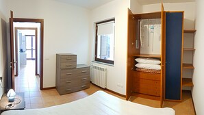 A bedroom with a bed, a dresser, a wardrobe, a radiator, and a window with blinds. - La Quiete 19 Holideal (Tremosine)