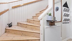 A wooden staircase with white walls and a mirror on the right. - Welcome Apartments (Jarfalla)