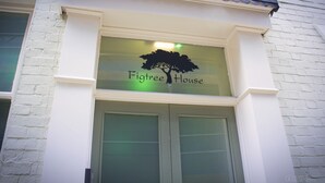 Fachada de edifício com uma placa que diz 'Figtree House'.