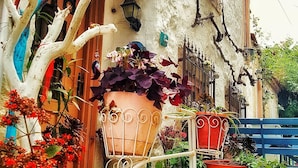 A rustic building with a sign reading "Ligurum," a metal bicycle, and various potted plants. - Lilyum Alaçatı Butik Otel (Cesme)