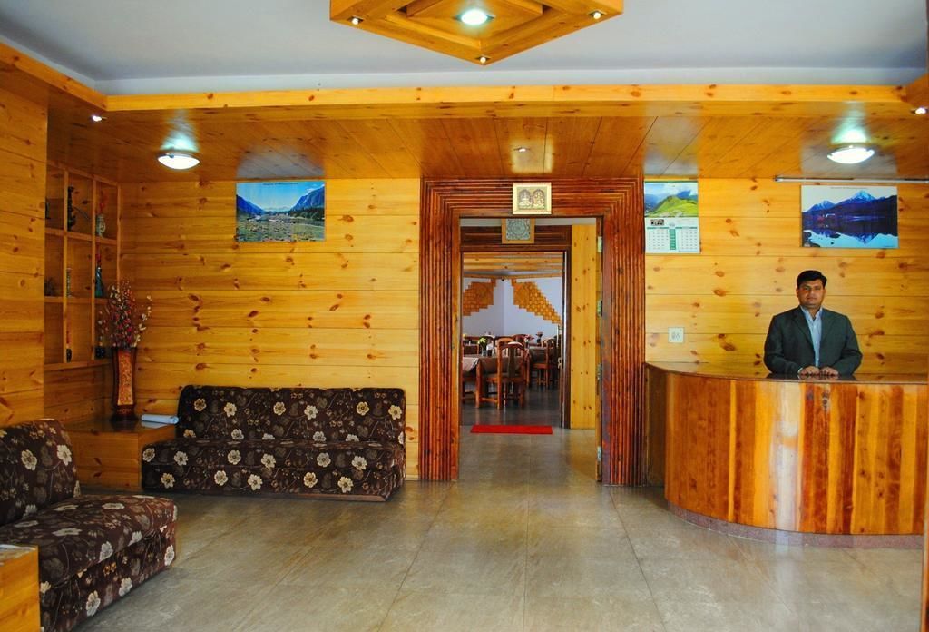Un interior de madera con mostrador de recepción, sofás y zona de comedor.
