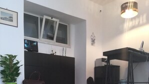 Moderni keittiö, jossa on musta työtaso, ruukkukasvi ja tervetulomatto.