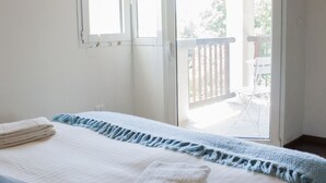A bedroom with a bed, a window, and a sliding door leading to an outdoor area. - Casa Bella Il Castello (Vergato)