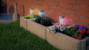 A brick wall with flower planters and decorative lights. - The cottage in Taddigshörn - nordseereise-net (Esens)