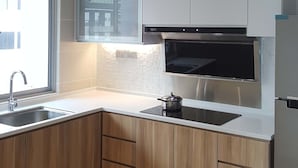A modern kitchen with white cabinets, a stainless steel sink, and a built-in oven. - SkyHabitat (Johor Bahru)