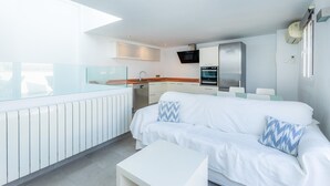 Een moderne keuken met witte kasten, een inbouwoven en een magnetron.