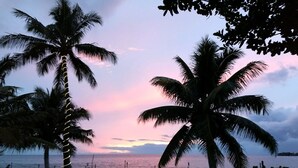 A sunset view with palm trees and a beach. - Makaha on the Beach-Back in Time =Direct Oceanfront & Cove (Waianae)