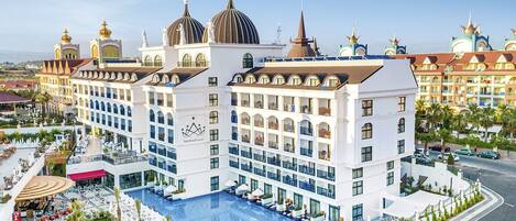 Et hotel med en stor swimmingpool, flere spisesteder og en central gårdsplads.