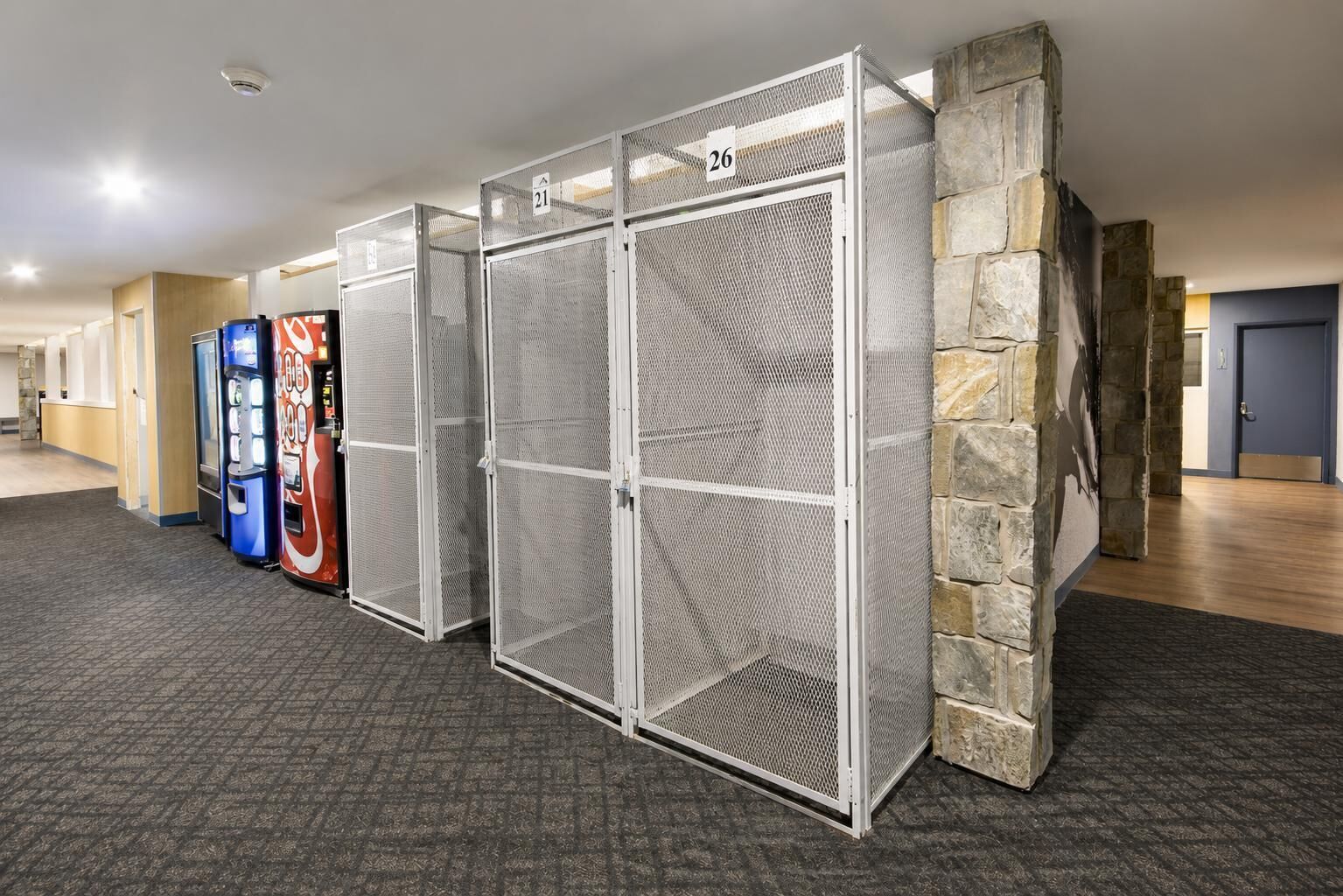 A row of numbered storage lockers with vending machines in the background.