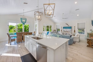 Enjoy meals in the kitchen with a central island, double sink, and dining area overlooking lush greenery.
