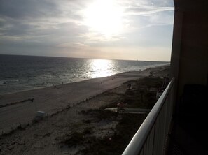 A beach view from a balcony with a clear sky and the sun setting over the ocean. - 2 Bedroom/2 Bath Beachfront!  (Panama City Beach)