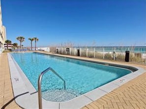 A rectangular swimming pool with a metal ladder, surrounded by a tiled deck and a metal fence. - 2 Bedroom/2 Bath Beachfront!  (Panama City Beach)