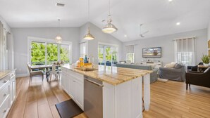 A modern kitchen with white cabinetry, a wooden countertop, and pendant lighting. - 4 Bed 4.5 Bath Family Friendly, 3 Blocks to Gulf (Anna Maria)