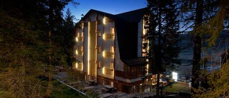 Un edificio a più piani dal design moderno, immerso in una fitta foresta.