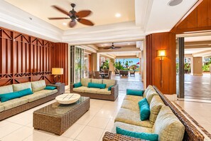 A spacious lobby with a high ceiling, a ceiling fan, and a view of the outdoor area.