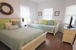 Une chambre avec deux lits, une table de chevet avec une lampe et une commode.